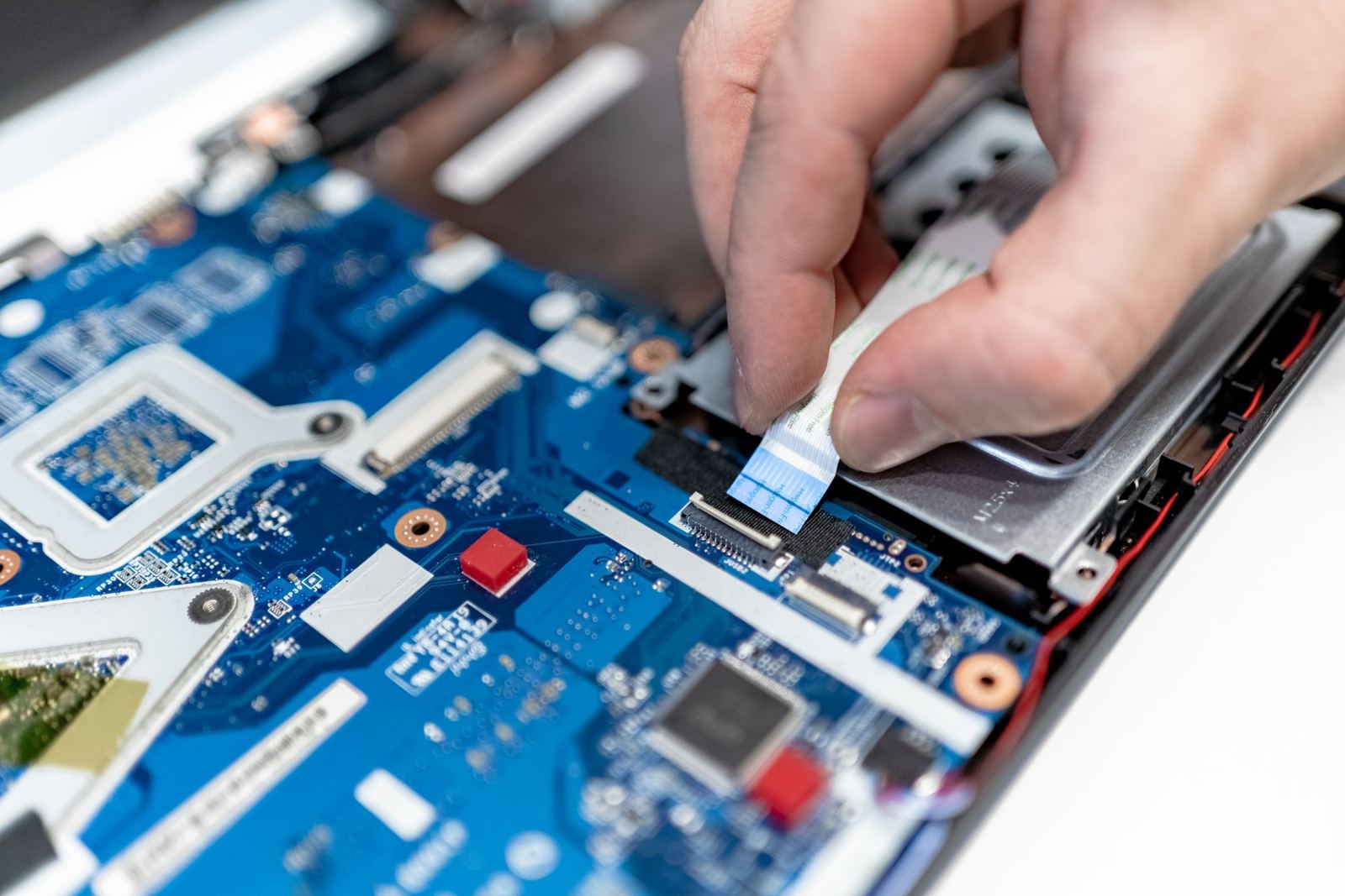 Mains qui démontent la carte mère d'un portable